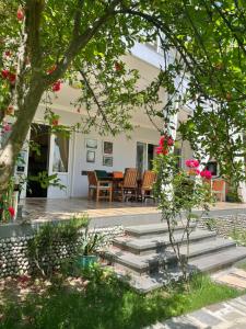 a patio with a table and chairs in front of a house at Neli & Zaal Guest House in Tʼelavi