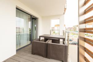 a table on the balcony of a building at Apartament Sea & City in Kołobrzeg