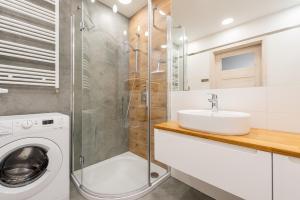 a bathroom with a washing machine and a sink at Apartament Sea & City in Kołobrzeg +9 photos