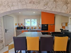 a kitchen with orange cabinets and a table with chairs at Casa Mathilde in Lecci