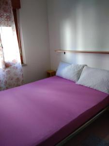a bedroom with a large purple bed with a window at Аppartamenti per vacanze, 500 m dal mare in Scalea