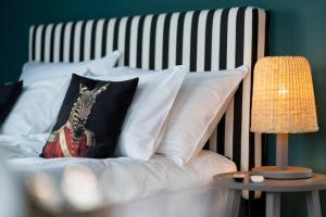 ein Bett mit weißen Kissen mit einem Bild eines Zebras in der Unterkunft Seeloft - a Sharp Hotel in Herrliberg