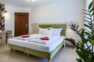 1 dormitorio con 1 cama con 2 toallas rojas en Paula Wellness & SPA, en Pobierowo