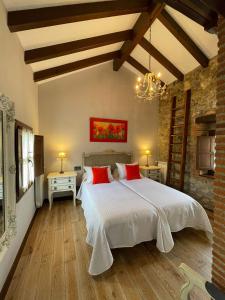 een slaapkamer met een groot wit bed met rode kussens bij Apartamento del s XVI en el casco histórico de Luanco in Luanco