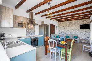 een keuken met blauwe kasten en een tafel met stoelen bij Casa Domingo in Villaverde
