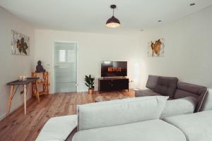 a living room with a couch and a tv at Ferienwohnung für die Familie, grosse Dachterrasse, Waschmaschine, Trockner in Senheim