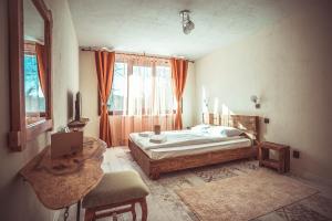 1 dormitorio con cama, mesa y ventana en Daulite boutique hotel en Rakovo