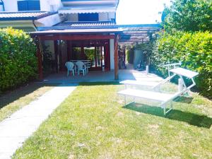 a patio with a table and chairs in the grass at Luxury Villa Duna Verde in Duna Verde