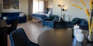 a living room with blue furniture and a table and chairs at Thon Partner Hotel Backlund in Levanger