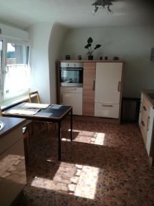 a kitchen with a table in the middle of a room at Schlössleblick in Wehr