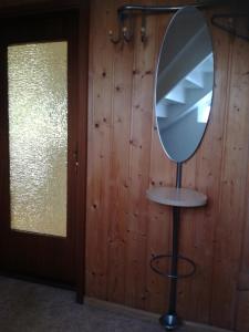 a mirror on a stand next to a wooden wall at Schlössleblick in Wehr
