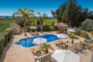 a swimming pool with umbrellas and tables and chairs at Villa Olympian Sun by Villa Plus in Peyia