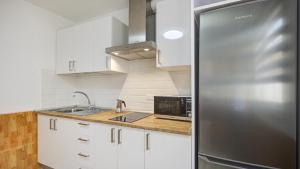 a kitchen with a stainless steel refrigerator and white cabinets at VALLES DE ORTEGA 6 in Valles de Ortega