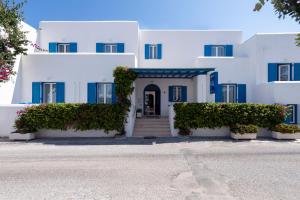 Casa blanca con persianas azules y escaleras en Ayeri Hotel, en Parikia