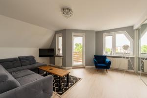 a living room with a couch and a blue chair at Szafir Apartament in Kołobrzeg