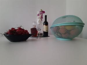 a bottle of wine next to a bowl of cherries and a bottle of wine at Apartman Jadranka in Rogotin