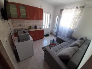 a living room with a couch and a kitchen at Apartman Jadranka in Rogotin