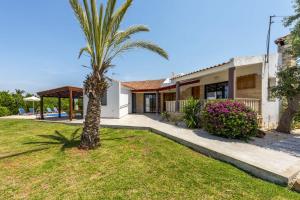 a palm tree in front of a house at Villa Theo Sapphire by Villa Plus in Lachi