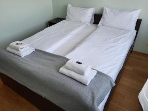 a large white bed with two towels on it at Apartament Centrum in Iława