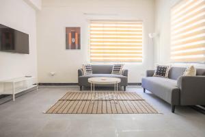 uma sala de estar com dois sofás e uma mesa em Neemtree Apartments - Somajiguda em Hyderabad