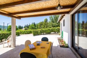 a patio with a table and chairs and a view of a yard at Apartment Laurel Leaf in Lovorno