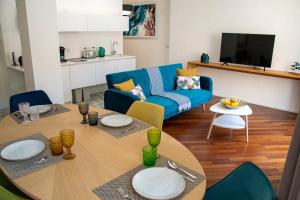 a living room with a table and a blue couch at Castalia Apartments & Rooms Duomo Taormina in Taormina