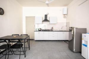 a kitchen with a table and a refrigerator at Neemtree Apartments in Hyderabad