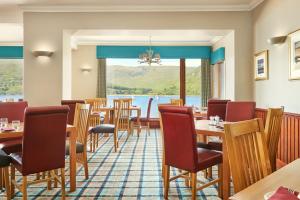 a restaurant with tables and chairs and a view of the water at Clan Macduff Hotel in Fort William