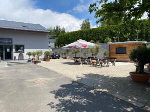 a patio with tables and benches and a building at hotel Nautilus in Chodov