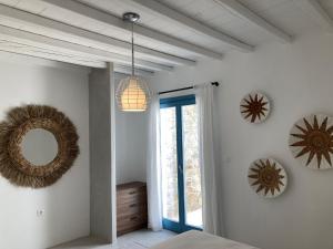 a bedroom with white walls and a blue door and mirrors at Sun House Paros in Kampos Paros