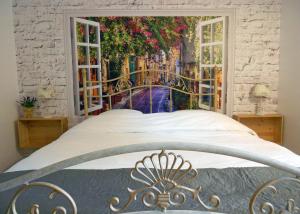 Un dormitorio con una cama con un cuadro en la pared. en Etoilevacances gites Tournesol en Olive, en Saint-Cézaire-sur-Siagne