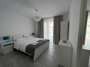 a white bedroom with a bed and a window at VAMA BLUE in Vama Veche