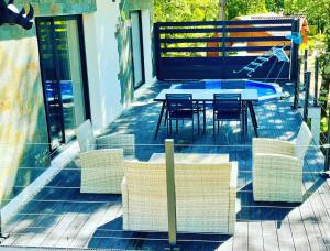 een patio met een tafel en stoelen en een zwembad bij Le Photinia in Le Bugue