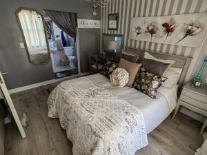 a bedroom with a large bed and a mirror at Marina La Vie in Jeffreys Bay
