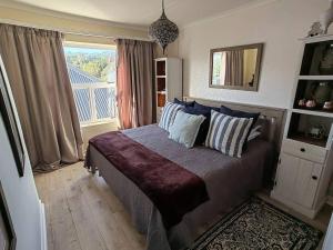 a bedroom with a bed with pillows and a window at Marina La Vie in Jeffreys Bay