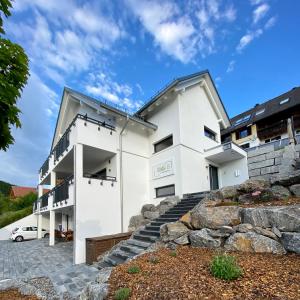 a white house with a car parked in front of it at Villa Number 8 in Feldberg