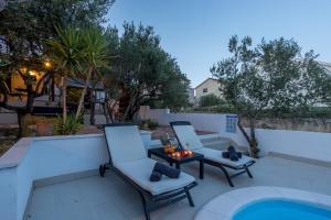 - une terrasse avec 2 chaises et une table à côté de la piscine dans l'établissement Compelx with detached house and spacious apartment, à Stari Grad