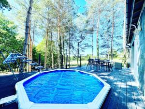 a swimming pool on a deck with a table at Le Photinia in Le Bugue