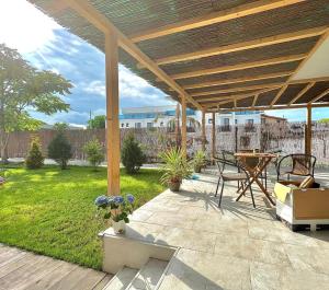 a patio with a wooden pergola and a table at VAMA BLUE in Vama Veche