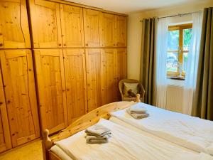 Schlafzimmer mit einem Bett mit Holzschränken und einem Fenster in der Unterkunft Ferienwohnung Stadlmann in St. Wolfgang