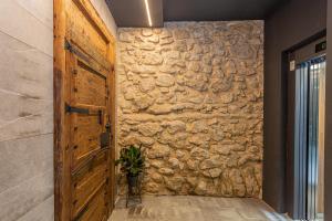 アリカンテにあるApartaestudios Evolution Luxuryの廊下の木製のドア付きの石壁