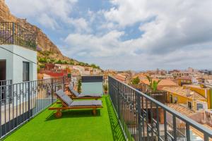 a balcony with a chair and a view of the city at Apartaestudios Evolution Luxury in Alicante