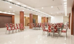 a dining room with red chairs and a table and chairsktop at Treebo Trend House Inn in Noida
