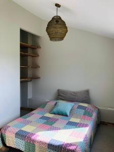 een slaapkamer met een bed met een kleurrijke deken bij Gîte à 10 minutes d'Anduze, au pied des Cévennes in Bagard