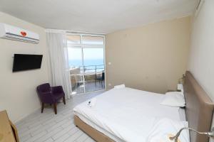 een slaapkamer met een bed, een raam en een stoel bij Park hotel in Netanya