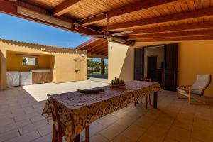 a patio with a table and a kitchen in the background at Casa vacanza Il Melograno in Santa Maria Del Focallo