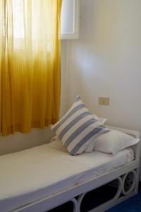 a bed with a yellow curtain and a window at Two bedrooms Capri style home near Piazzetta in Capri