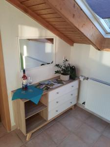 a dressing table with a mirror and a bottle of wine at Ferienwohnung Brendle in Sankt Johann
