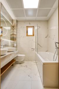 a bathroom with two sinks and a tub and a toilet at Quercus Residences Apartments in Sveti Stefan
