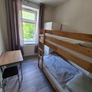 a bedroom with two bunk beds and a desk and a window at Altstadt Hostel Bremen in Bremen